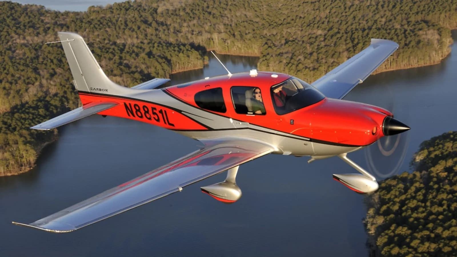 Cirrus SR22 Carbon im Reiseflug über bewaldeter Seenlandschaft
